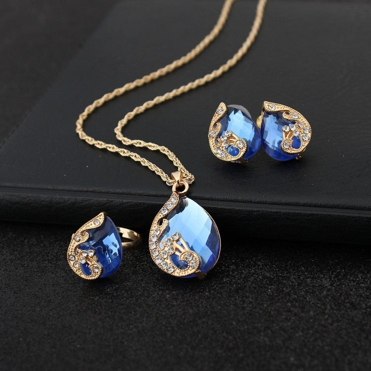 Pia – Parure Collier et Boucles d’Oreilles en Cristal Bleu et Doré
