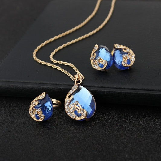 Pia – Parure Collier et Boucles d’Oreilles en Cristal Bleu et Doré