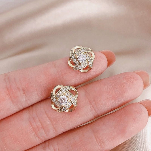 Elara – Boucles d’Oreilles Croix en Fleur Torsadée